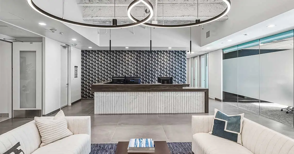Modern office reception with curved lighting, front desk, and seating area