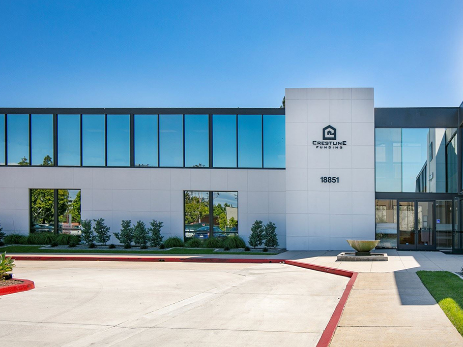 White Building with reflective glass and clear blue skies behind