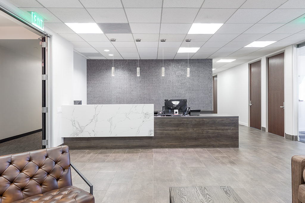 Reception desk with 4 light fixtures and textured wallpaper behind