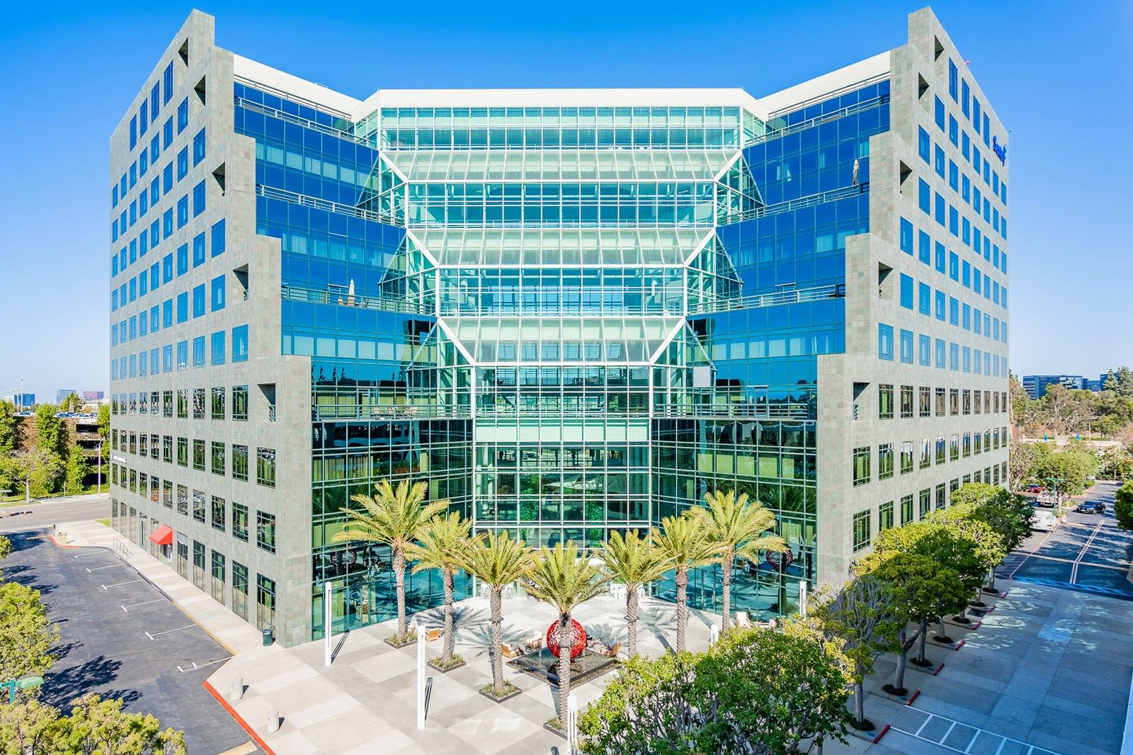 Modern glass office building with palm trees