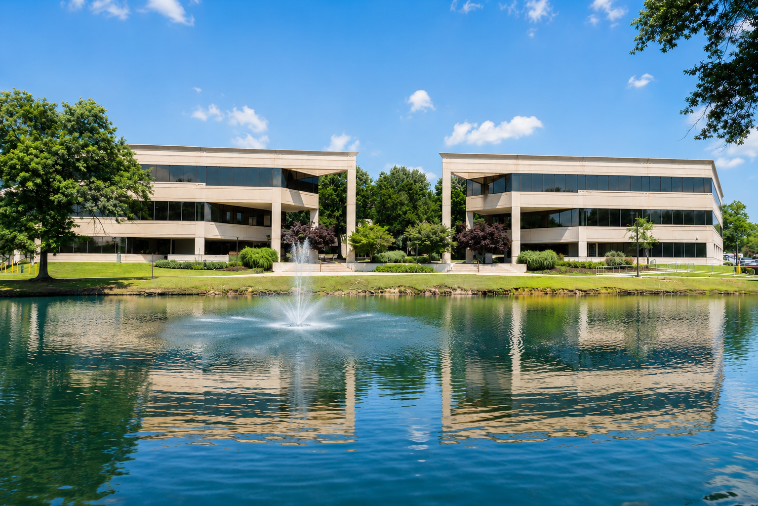 2 buildings in front of a fountain and lake