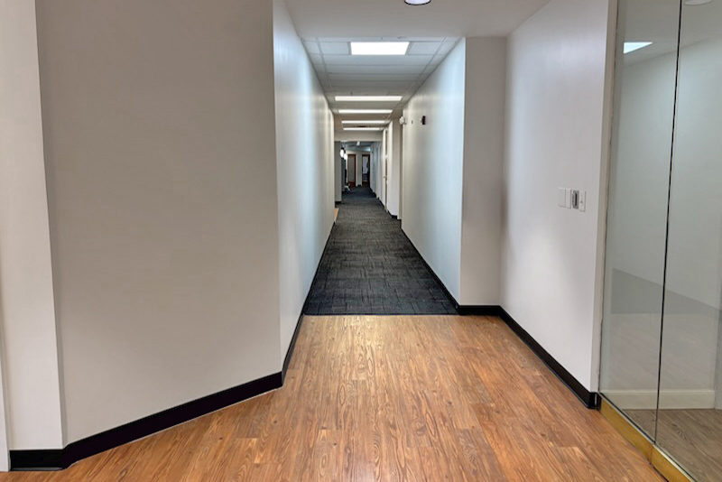 Long, empty hallway with wooden floor