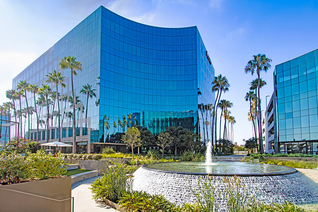 Modern glass building with palm trees