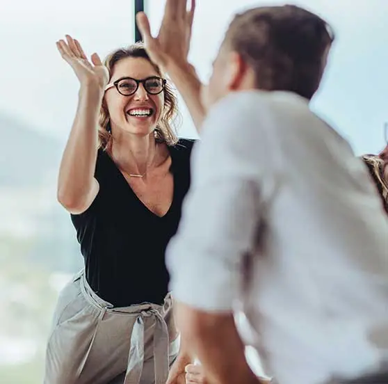 Team members giving a high five in a meeting