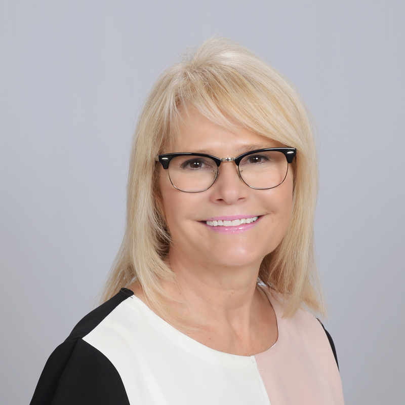 Woman with blonde hair, neutral expression.