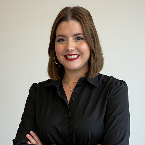 Woman with short brown hair in a long sleeve black shirt smiling at the camera
