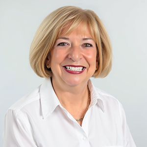 Woman with short blonde hair smiling at the camera